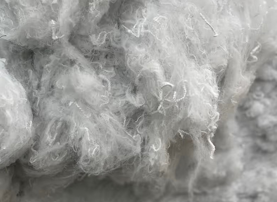 Close-up of recycled polyester fibres showing fine white synthetic strands used in insulation and technical applications.